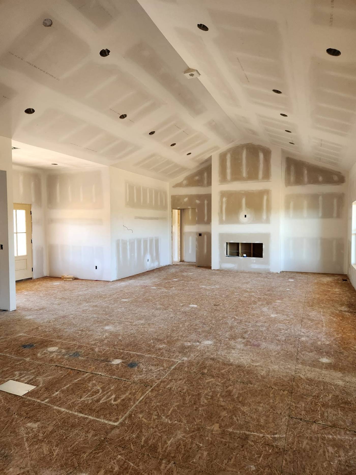 Vaulted great room with fireplace in a custom home during the drywall stage